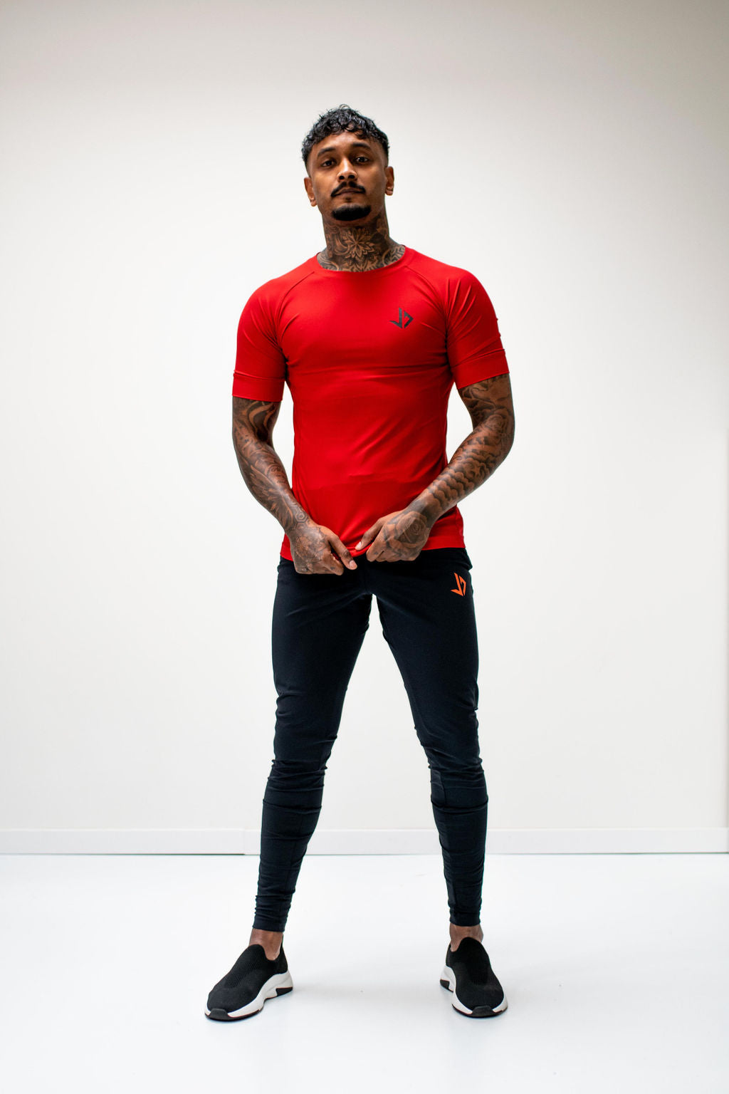 Lange man draagt zwarte extra lange trainingsbroek van JUSS7 Sportswear