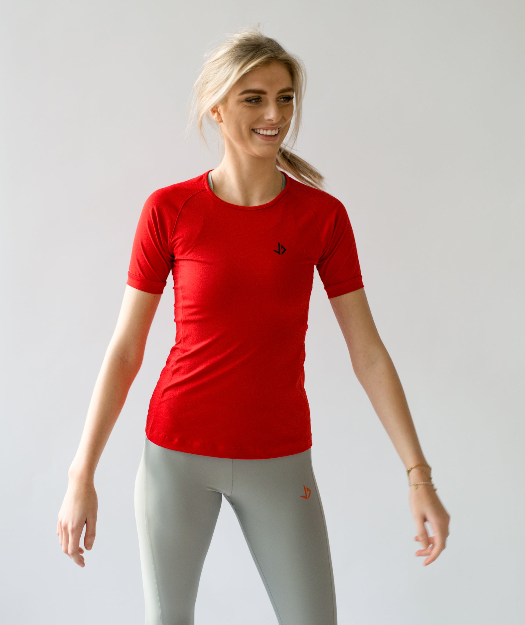 Lange vrouw draagt rood sportshirt met korte mouwen van JUSS7 Sportswear
