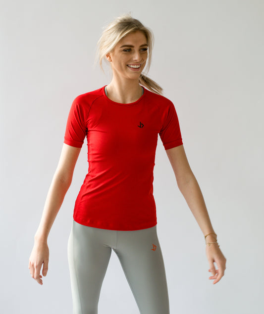 Lange vrouw draagt rood sportshirt met korte mouwen van JUSS7 Sportswear