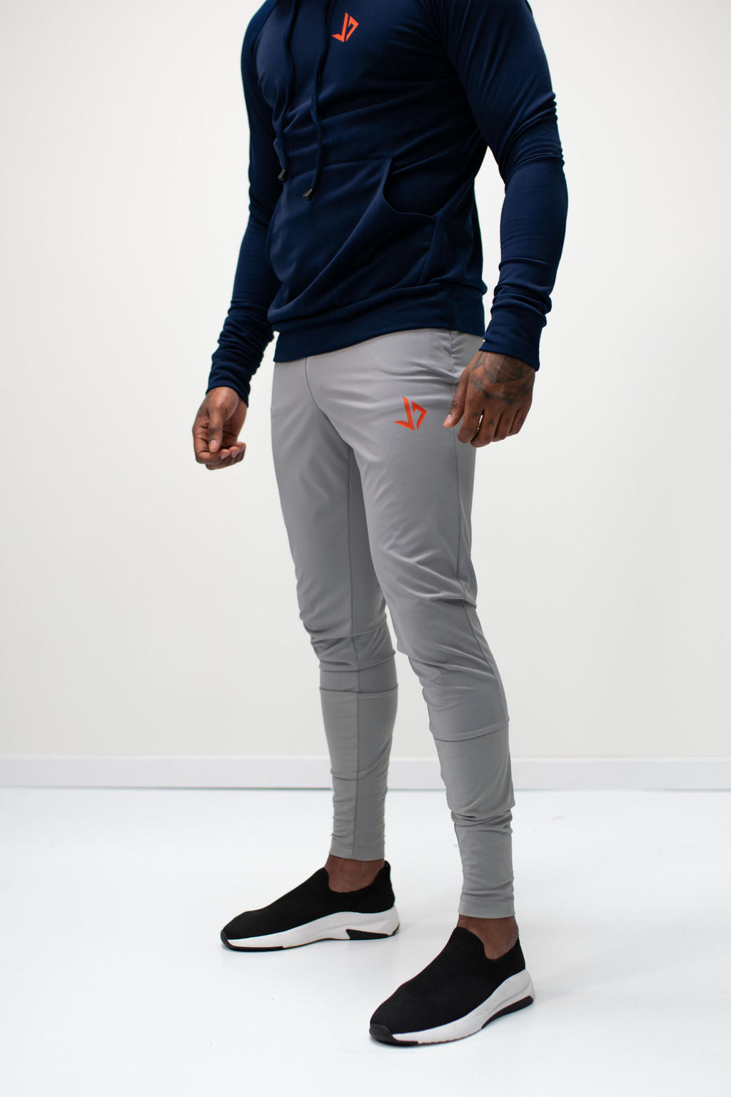 Lange man draagt zwarte extra lange trainingsbroek van JUSS7 Sportswear