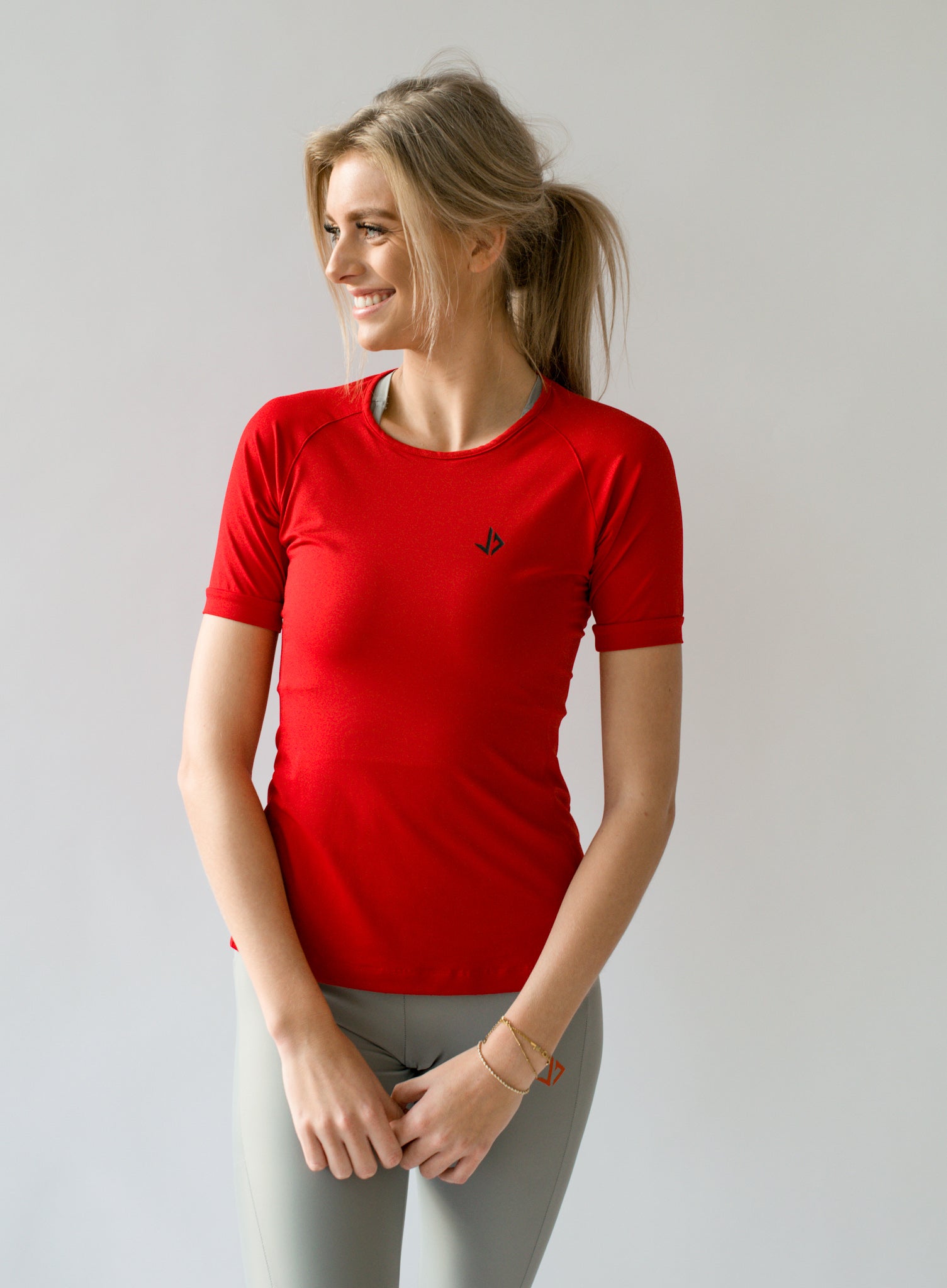 Lange vrouw draagt rood sportshirt met korte mouwen van JUSS7 Sportswear